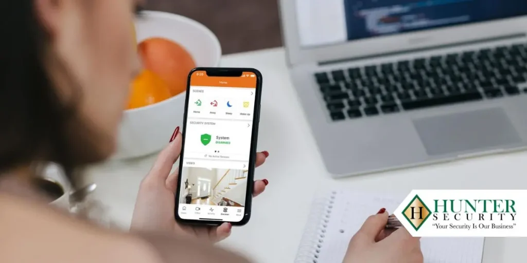 Homeowner reviewing a security system app on a smartphone before signing an alarm contract