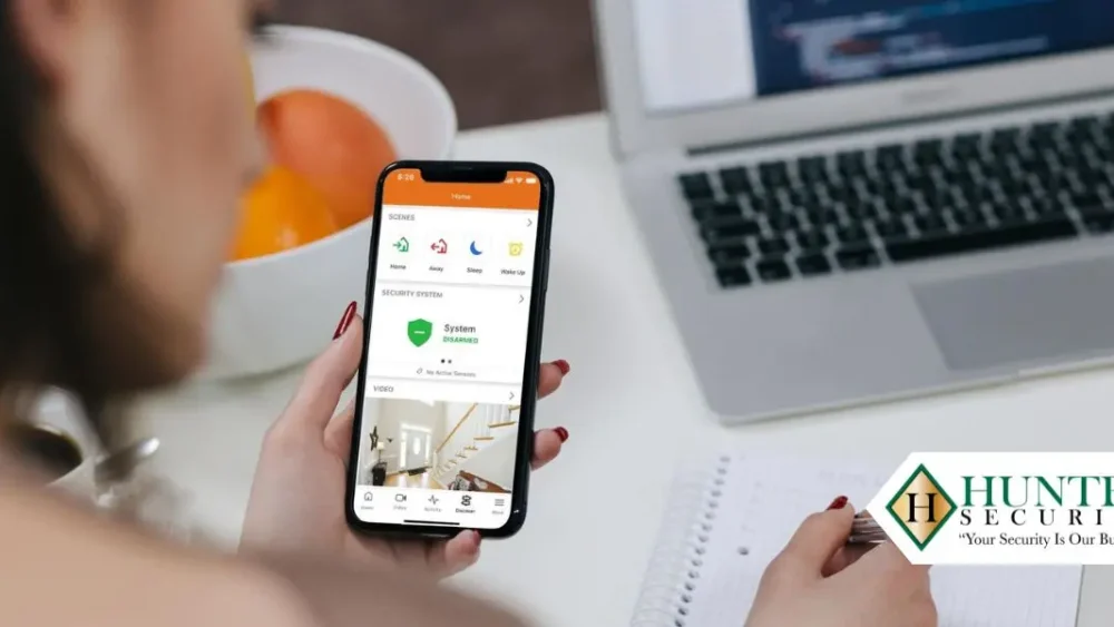 Homeowner reviewing a security system app on a smartphone before signing an alarm contract